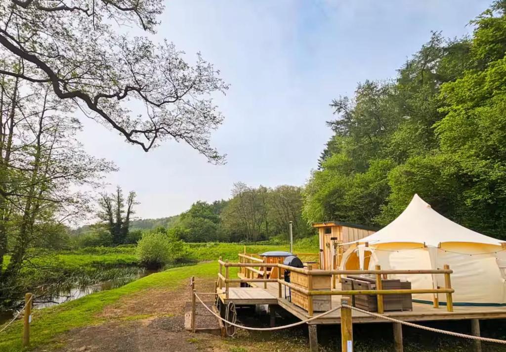 a yurt on a dock next to a river at Roden Retreat in Aston