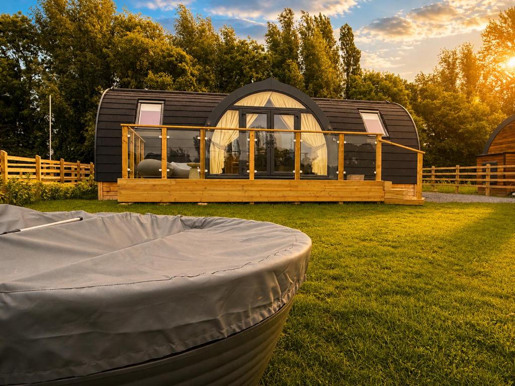 a small house with a cover in the grass at Leisure Lodges in Glastonbury