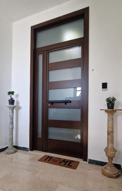 a wooden door in a room with two vases at Damhomeitaly in Modena