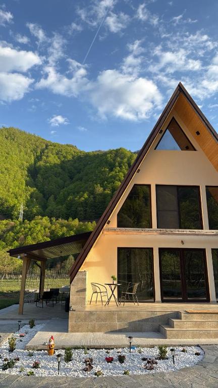a house with a roof with a table and chairs at LaMonte Retreat in Brezoi