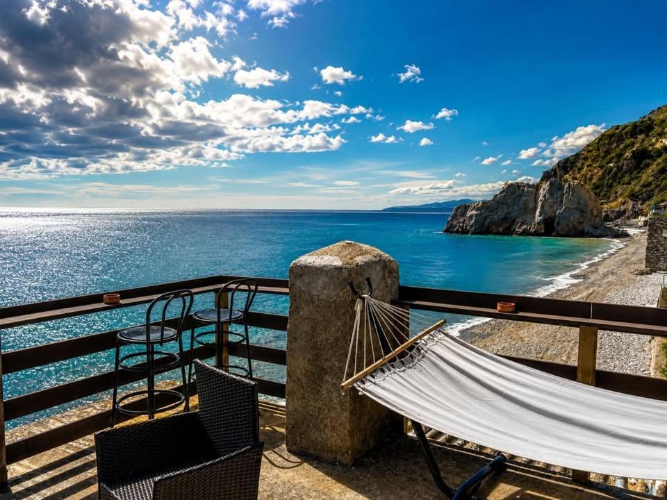 a hammock and chairs on a balcony overlooking the ocean at Melinda Tower in Plomari