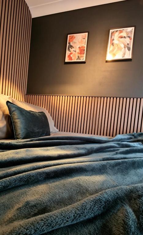 a bedroom with a bed with three pictures on the wall at The Hideout Middlesbrough Great Location in Middlesbrough
