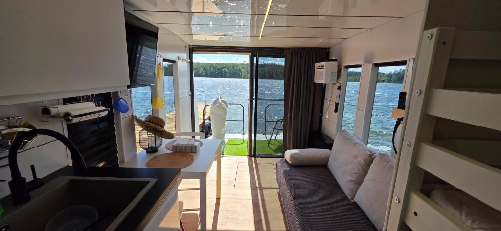 a kitchen and living room with a view of the water at Houseboat Bella in Tereszewo