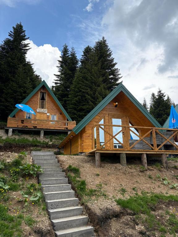 a wooden cabin with a staircase in front of it at KOMOVI - Dream house - 2 in Andrijevica
