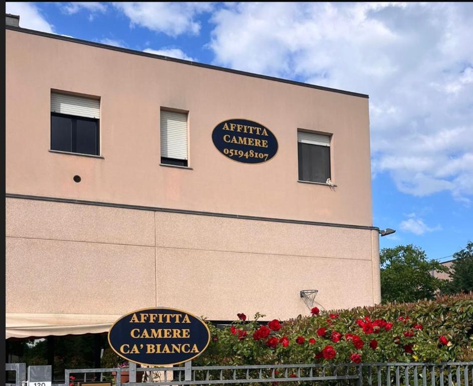 a building with two signs on the side of it at Affittacamere Cà Bianca in Casa Rossa