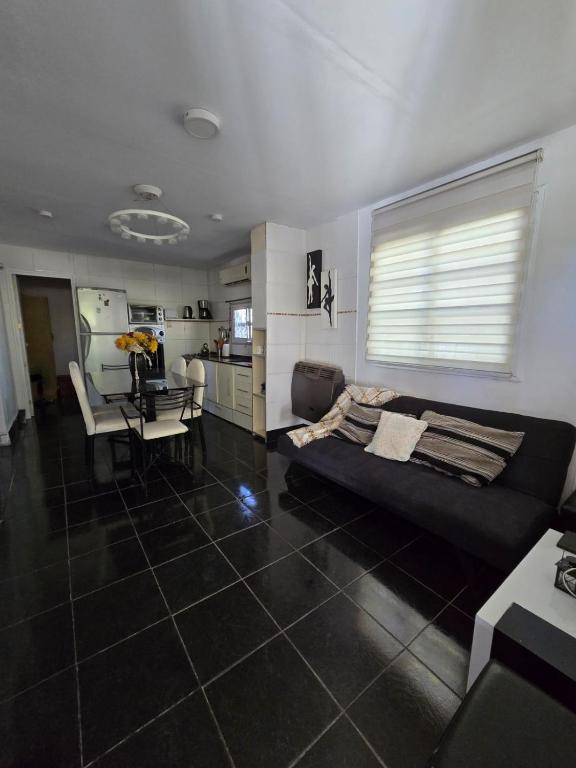 a living room with a black couch and a table at Departamento en San Juan Capital 3 dormitorios hasta 6 personas in San Juan