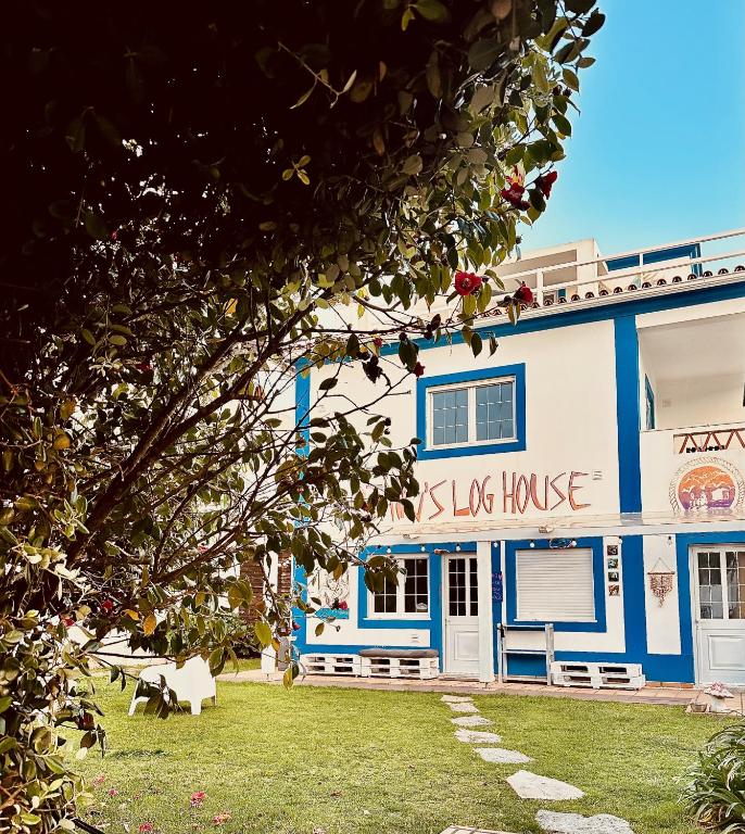 a blue and white building with a dog house at Captain's Log House in Baleal