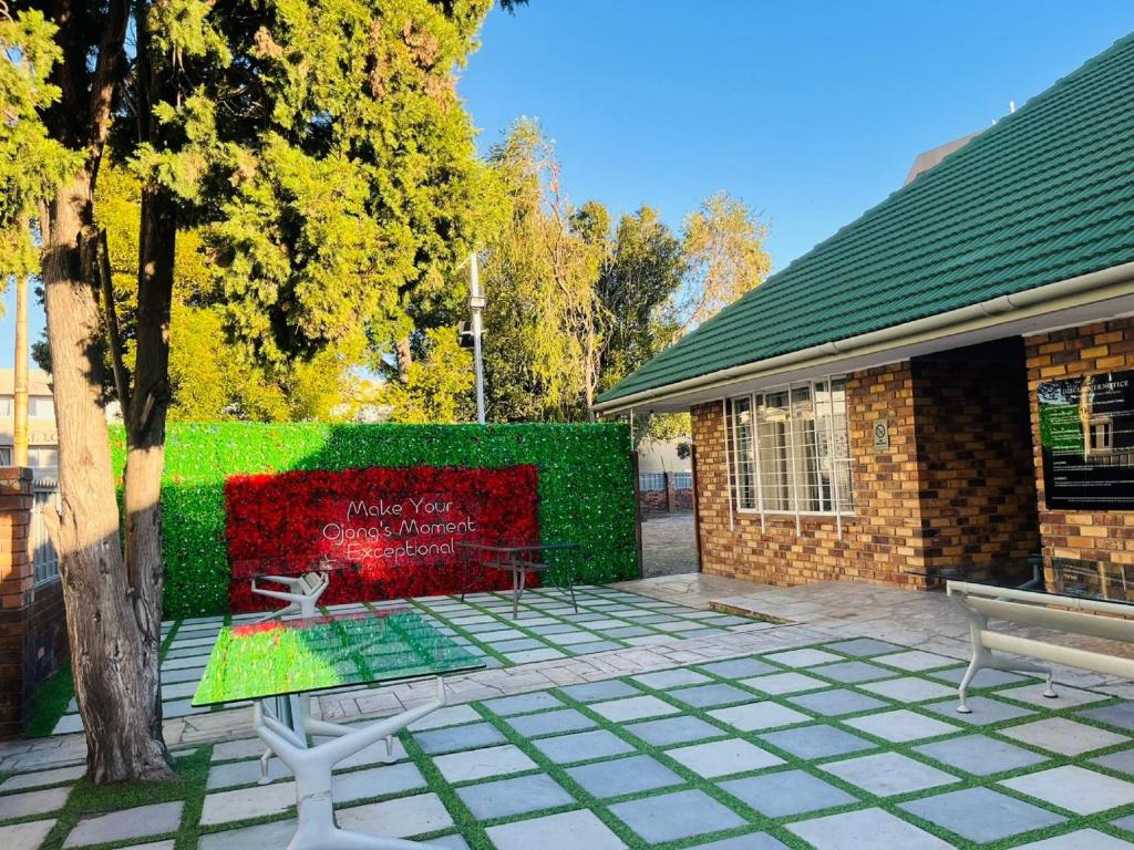 a building with a bench and a green hedge at Ojong's Self Catering Accommodation Bellville in Cape Town