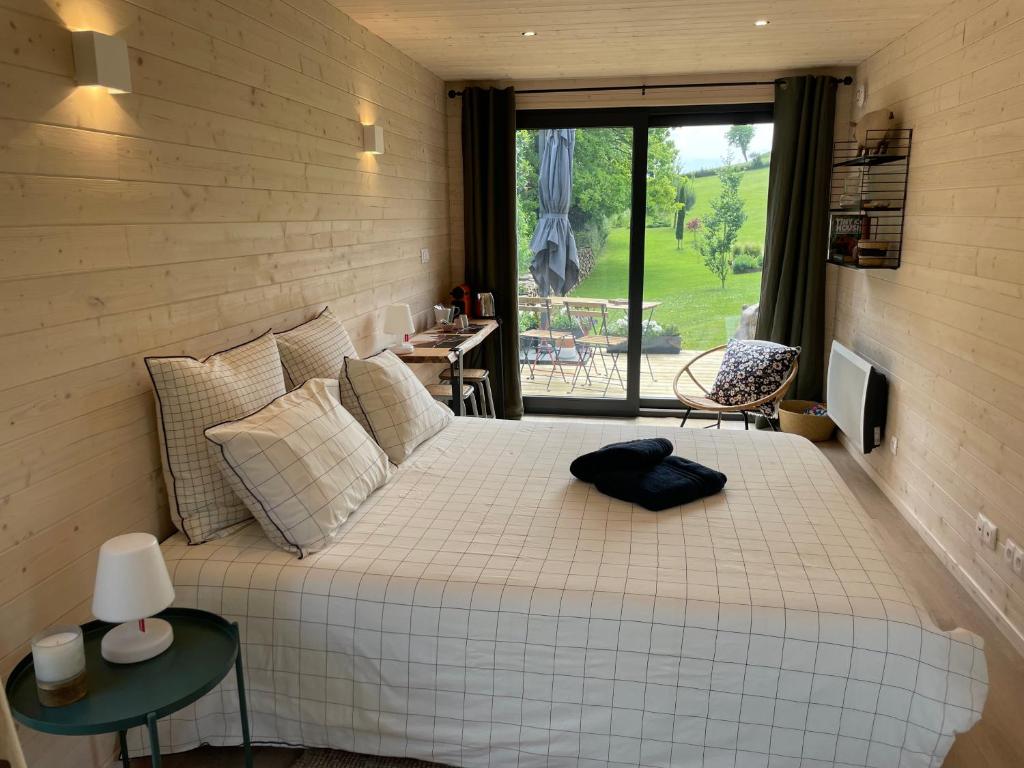 a bedroom with a large white bed and a window at Le Lodge de la Course in Beussent