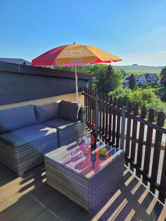 a patio with a couch and an umbrella at Bella Vista in Burgstaedt