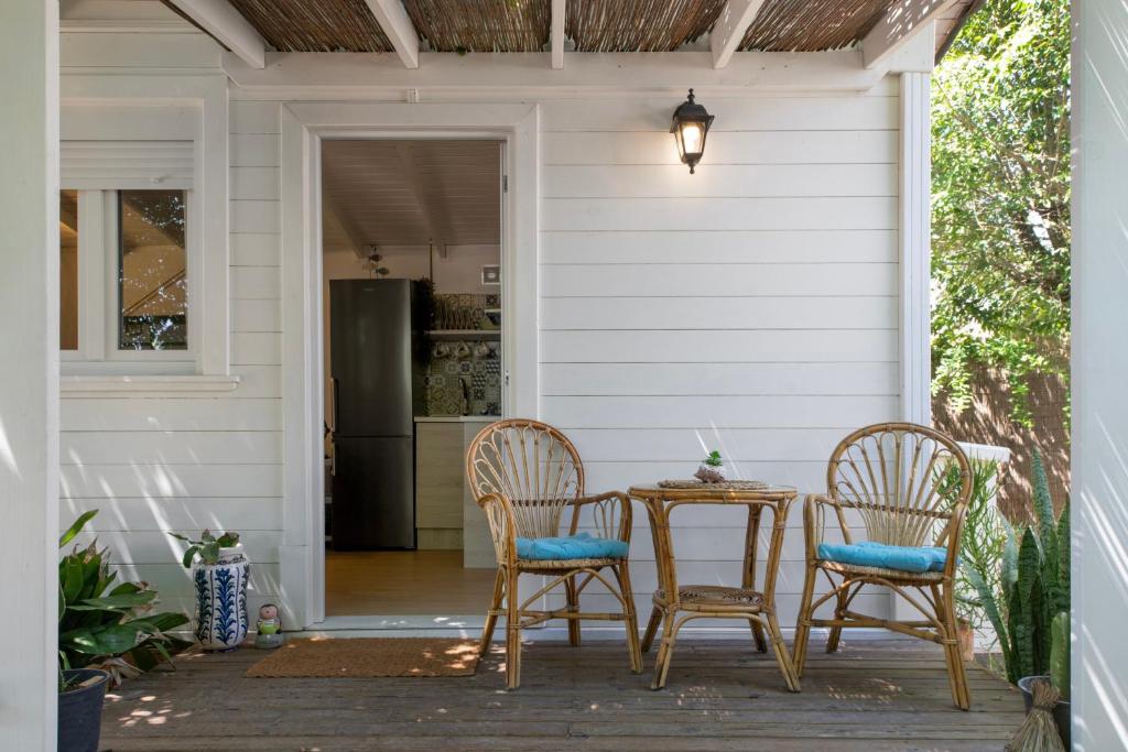 a porch with a table and chairs and a refrigerator at Tiny House La Loma in Barbate