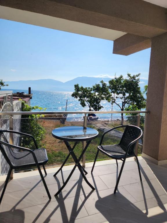 a table and two chairs on a balcony with the ocean at Lakefront House in Pogradec