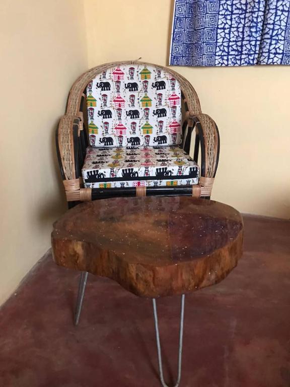 a wooden chair with a table in front of it at Jedd Palace in Kpannou