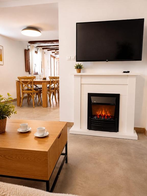 a living room with a fireplace with a tv above it at Casa Rural Las Alcusa in Cubla