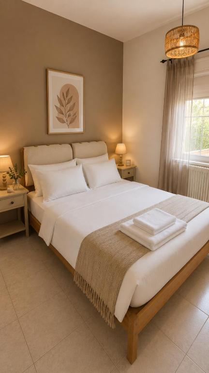 a large white bed in a bedroom with a window at Camvas Apartments in Panormos Kalymnos