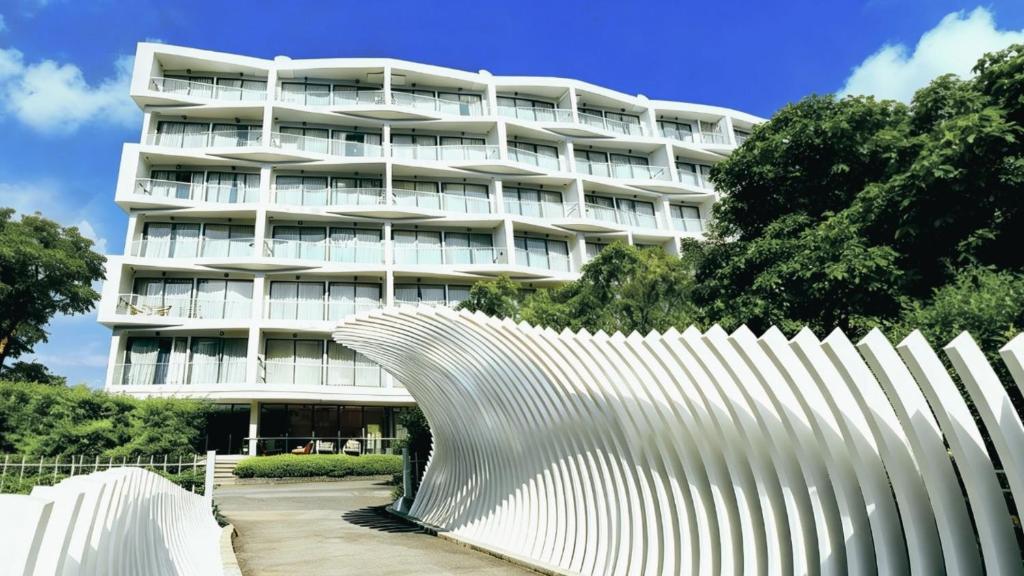 a white building with a white fence in front of it at Laya Suites and Residences in Bang Tao Beach
