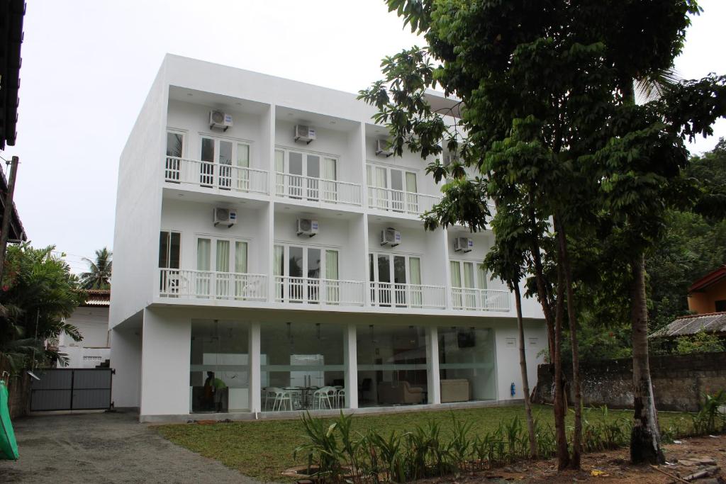 a large white building with a balcony at Heaven By O in Unawatuna