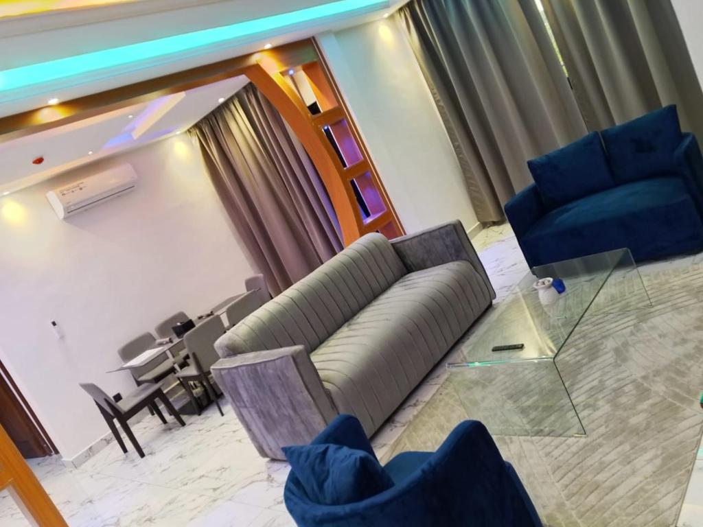 a living room with a couch and chairs and a table at Logements Majeo in Bikondo