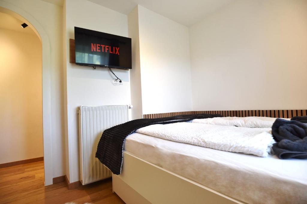 a bedroom with a bed and a tv on the wall at Ries Rosina - bei LKH GRAZ - NEUERÖFFNUNG - Self Check In 24-7 in Graz