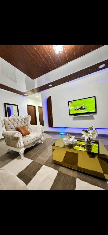 a living room with a couch and a tv on a wall at Cintya Maria in Camama