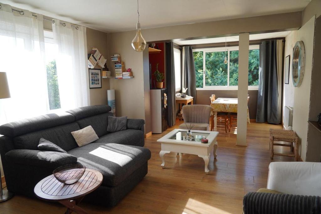 a living room with a couch and a table at logement avec jardin de bord Mer PORT NAVALO in Arzon