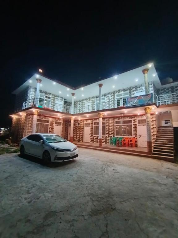 a car parked in front of a building at night at Homeland Hotel and Resort in Burāwai