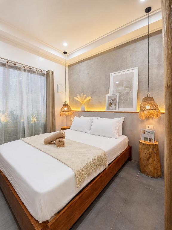 a bedroom with a large bed and a window at White Palm Villa 1 in General Luna