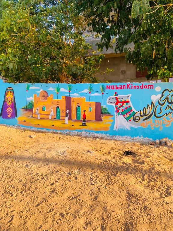 a wall with a painting of a house and a camel at Nubian kingdom in Aswan