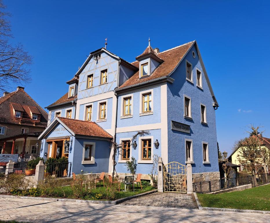 a large blue and white house with a fence at Hotel Bezold in Rothenburg ob der Tauber