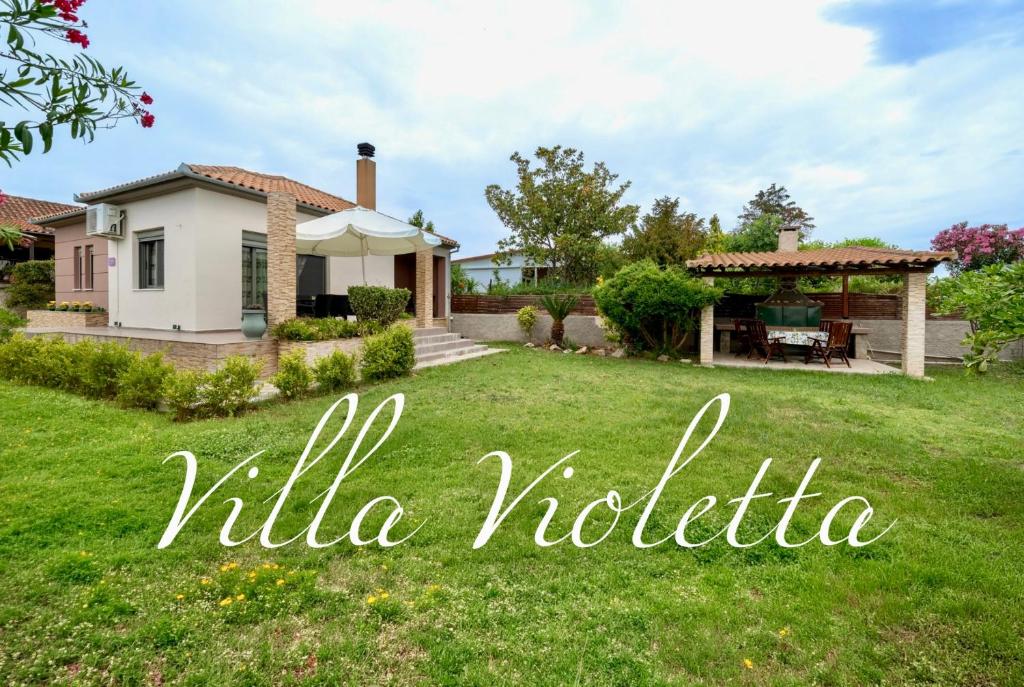 a house with a yard with the words villa toledka at Villa Violetta in Nea Anchialos