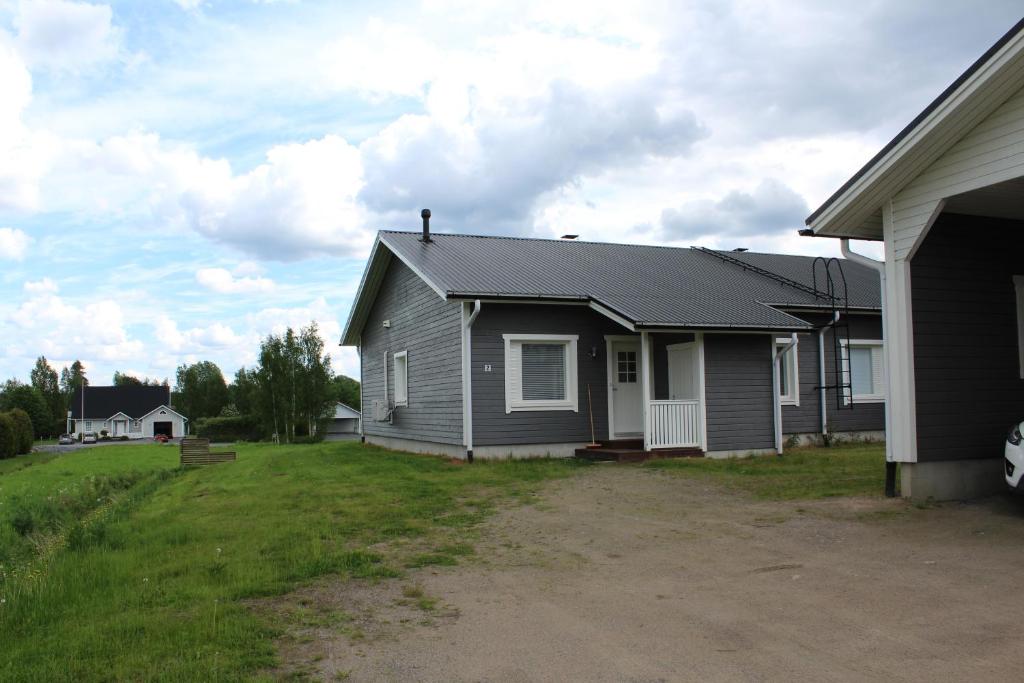 a gray house with a yard next to a house at Pikkurinki 27 As 2, Härmä in Härmä