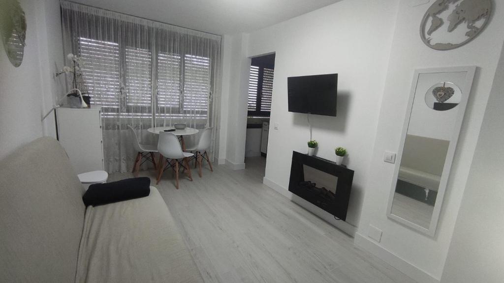 a white living room with a fireplace and a table at Sky in Noja