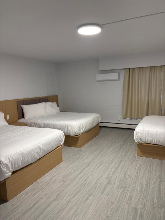 a hotel room with two beds and a window at Rundle Inn and Suites in Edmonton