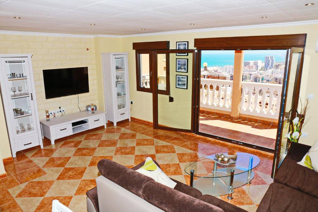 a living room with a couch and a television at Villa de Mediterraneo Cullera in Cullera