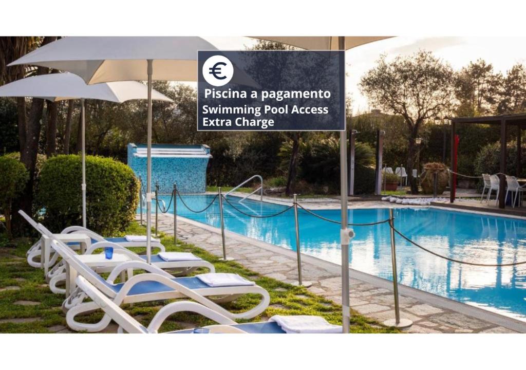 a sign in front of a swimming pool with lounge chairs at Sarzana Park Hotel in Sarzana