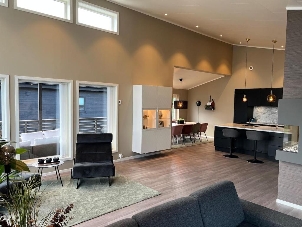 a living room with a couch and a table and a kitchen at Moderne enebolig med gratis parkering in Alta