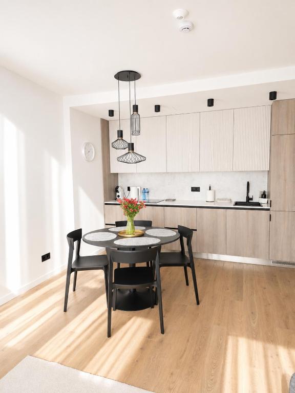 a kitchen and dining room with a table and chairs at Haustory Deluxe Apartment in Klaipėda