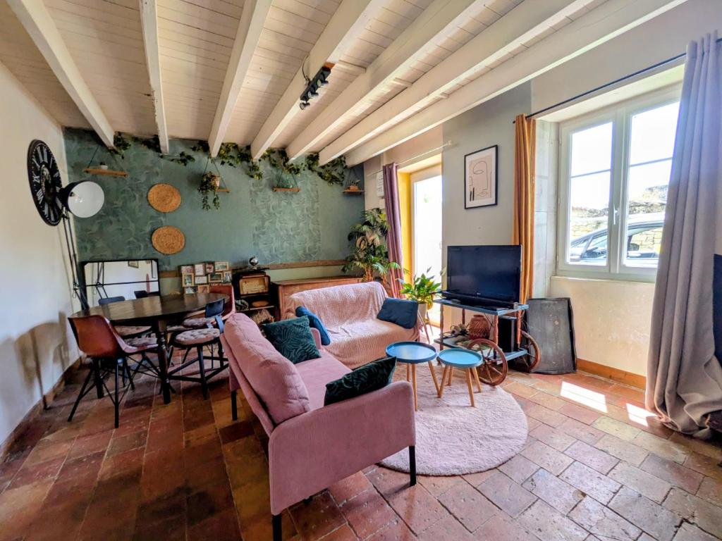 a living room with a couch and a table at Le calme de la campagne proximité Center Parcs in Saint-Léger-de-Montbrillais
