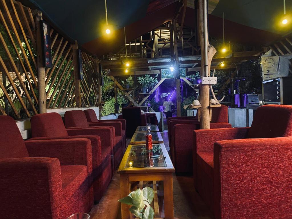 a row of red chairs and a table in a room at Sea secret in Arugam Bay