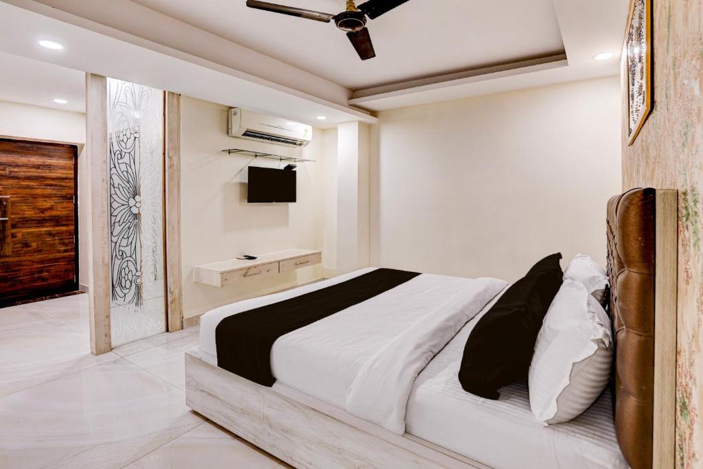 a bedroom with a bed and a tv in it at Townhouse OAK The Hotel Square Villa in Ghaziabad