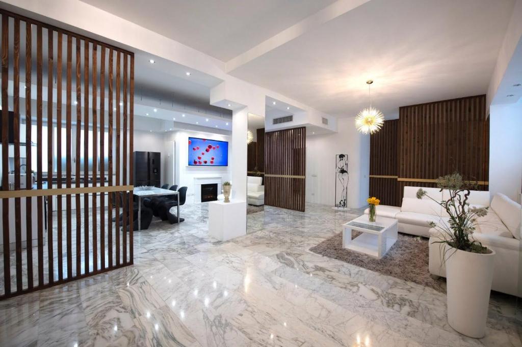 a living room with a couch and a tv at La Galleria Milano - 160 sqm Design Apartment, Spa & Parking in Milan