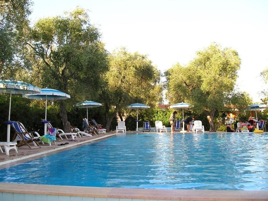 a large swimming pool with chairs and umbrellas at Vieste Residence Gallo Con Piscina in Vieste