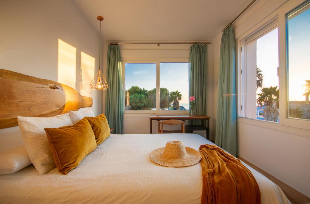 a bedroom with a bed with a hat on it at Hotel Fortuna in Los Caños de Meca