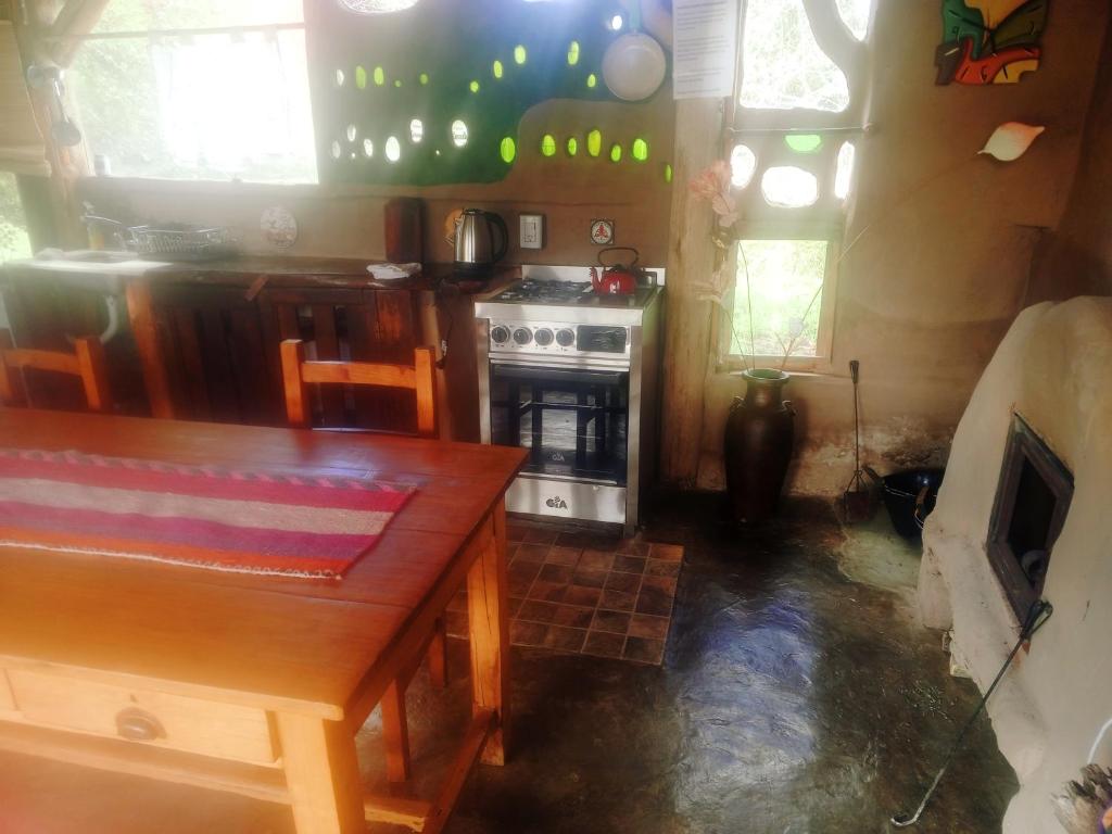 a kitchen with a wooden table and a stove at Gentil Morada in Villa Yacanto
