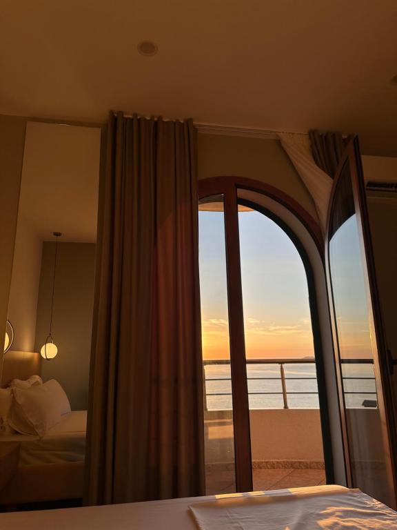 a bedroom with a bed and a view of the ocean at Lùmar Hotel in Vlorë
