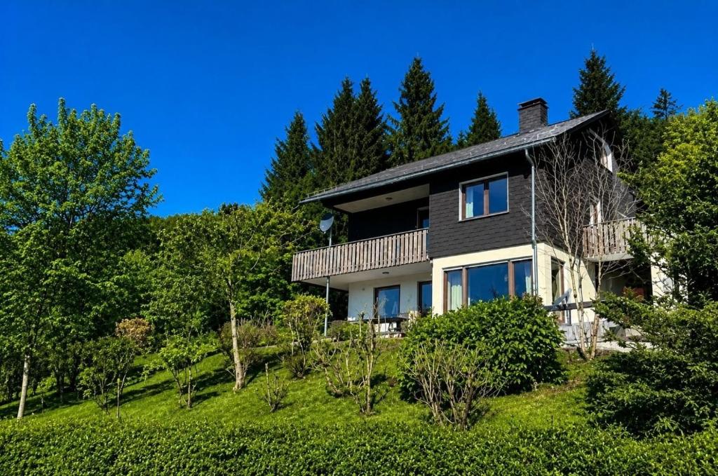 a house on top of a hill with trees at Chalet BERGglück Willingen - Nähe Skilifte in Willingen