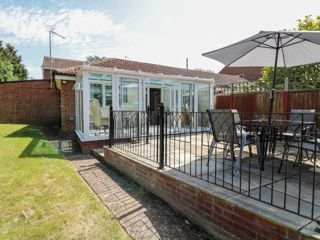 a house with a deck with an umbrella at 51 Colin McLean Road in East Dereham