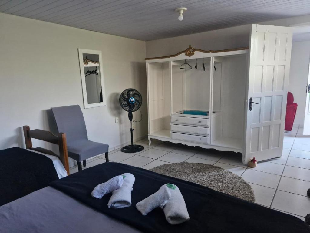 a bedroom with a bed with two pairs of slippers at Flat Casa Grande in Itapira