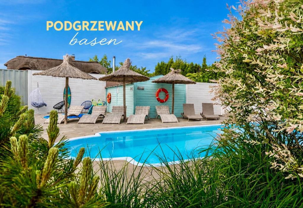 a pool at a resort with chairs and umbrellas at Sea You Stegna in Stegna