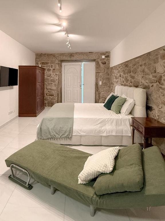 a bedroom with two beds and a couch in it at Casa Bossa Nova in Fundão